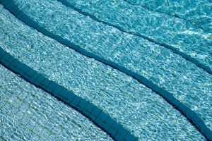 Close-up view of clear swimming pool water with tiled bottom
